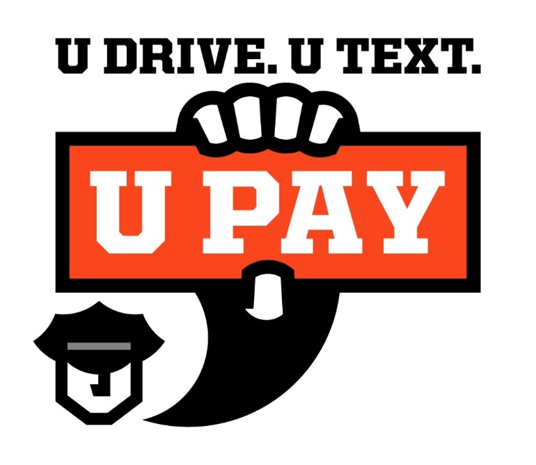 Police officer holding a sign that says "U Pay" if you text and drive.