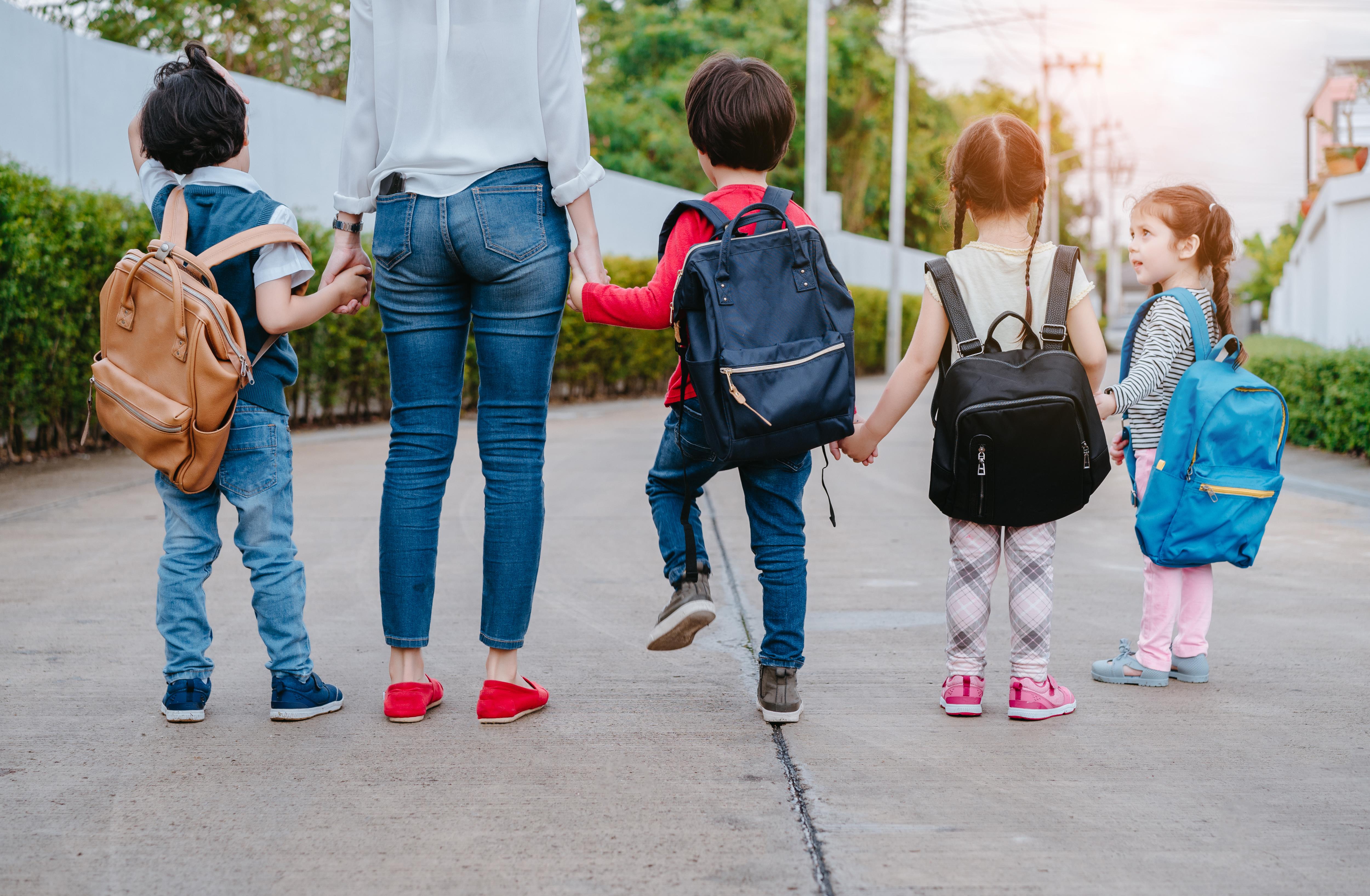 Adults  holding hand with four preschoolers