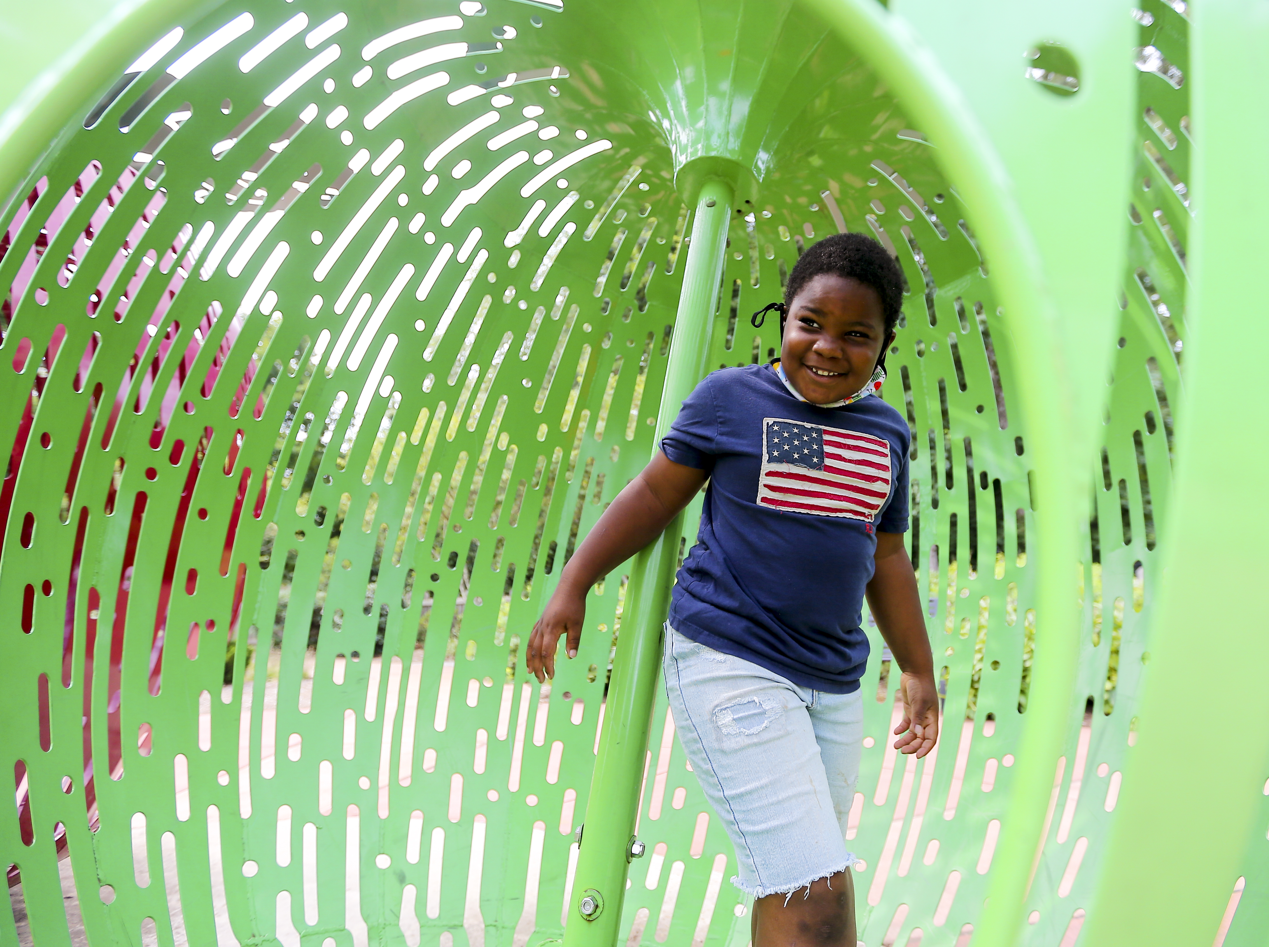 Child walks through sculpture of an apple