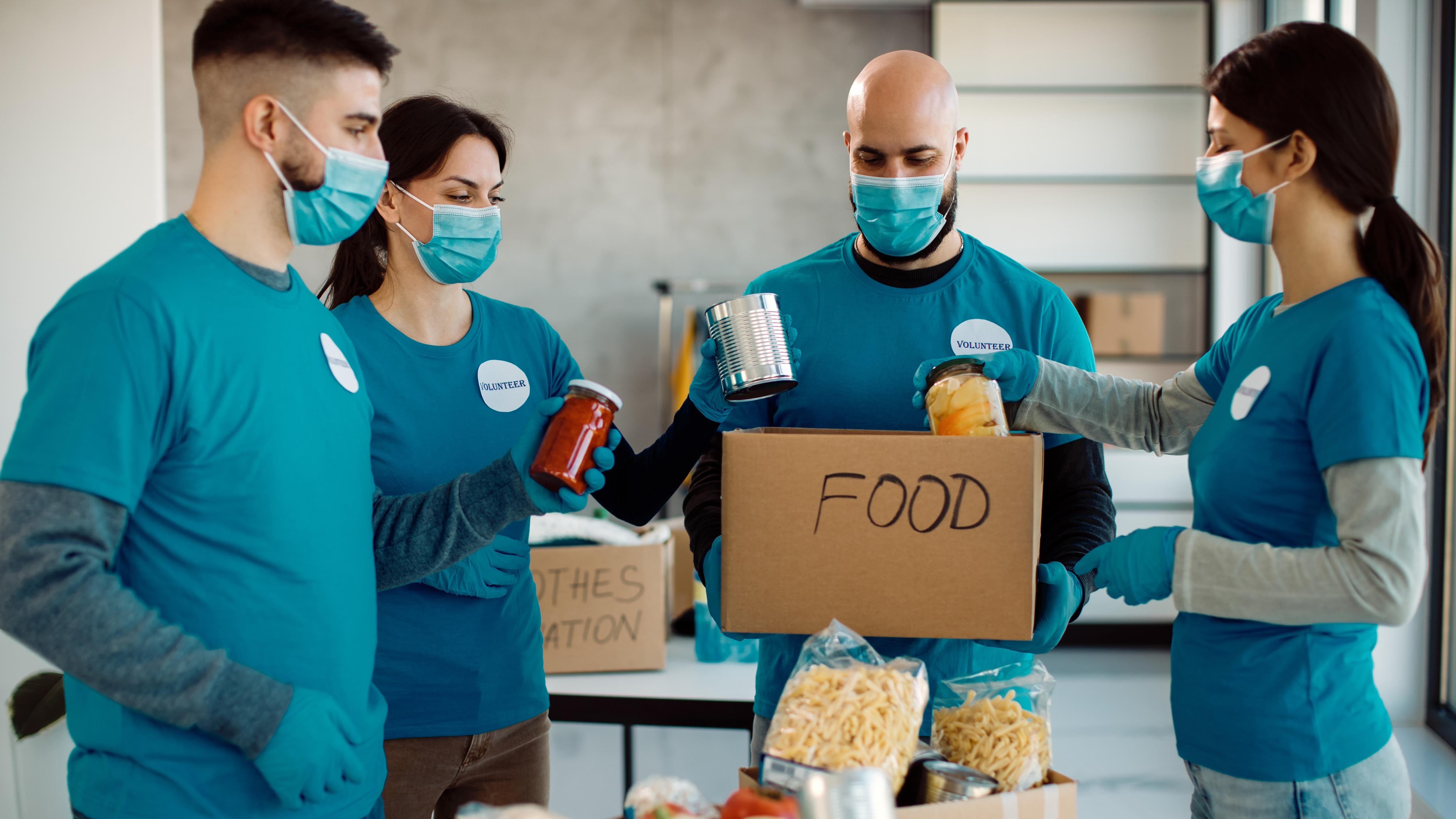 Volunteers putting canned goods in box