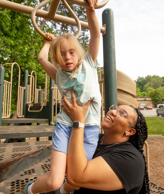 Jaliah Singleton with student on playground rings